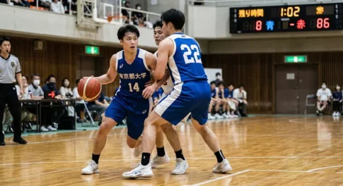 バスケットボールの試合でピックアンドロールを仕掛けるガード選手と、スクリーンをかける選手の連携プレー。ディフェンスを崩すための基本的な戦術シーン。