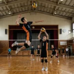 体育館でバレーボールのスパイクを打つ選手。ハイキューの烏野高校を彷彿とさせる黒とオレンジのユニフォームを着用し、セッターのトスに合わせて高くジャンプする躍動感あふれる実写シーン。