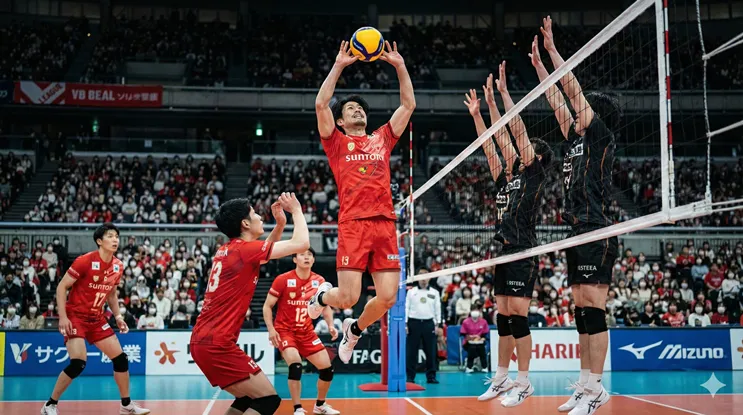 Vリーグ・サントリーサンバーズの大宅真樹選手(背番号13)が、赤いユニフォームを着用して試合中にジャンプトスを上げる様子。背後には観客席とネット際のブロック、ミカサ製の公式球が写るプロバレーボールのアクションシーン。