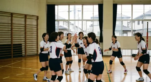 体育館で笑顔でハイタッチを交わす9人制ママさんバレーボールチームの選手たち