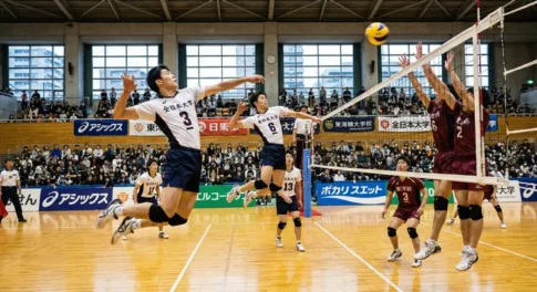 全日本大学バレーボールの試合シーン。背番号3番と6番の選手が同時にジャンプしてスパイクを狙う、同時多発位置差攻撃（シンクロ攻撃）のパターン。ネット際で対峙する3枚のブロック。