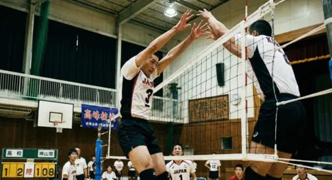 バレーボールのブロック技術：ネット際で高くジャンプし、両腕を真っ直ぐに伸ばして相手の攻撃を防ぐ選手の理想的なフォーム