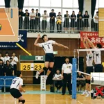 バレーボールの基本ルールと得点方法の初心者向け解説図。コート内にボールが落ちて1ポイント入る仕組み、アタッカーのスパイクトスとブロックの攻防、およびネット際やドリブルなどの反則(フォルト)を赤いバツ印で示す図解写真。スコアボードは25-23を表示。