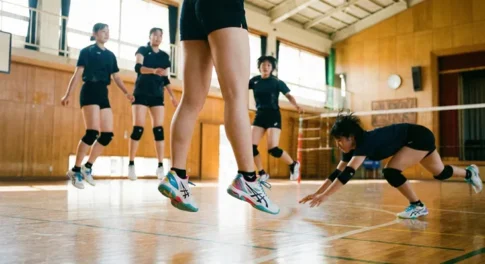 体育館でバレーボールの練習をする女子選手たちと、ジャンプする足元を支えるレディース・ジュニア向けバレーボールシューズ