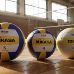 体育館の床に並べられた3種類のバレーボール。左からミカサ(MIKASA)の5号球、4号球、モルテン(molten)の検定球を並べてサイズを比較している様子。